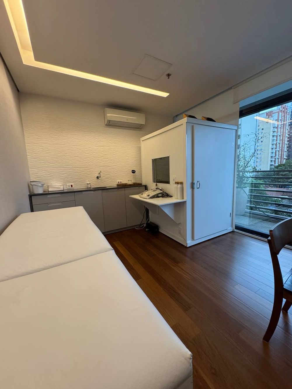 Sala de exames com maca, bancada e cabine acústica